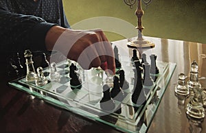Player at chessboard moving a piece