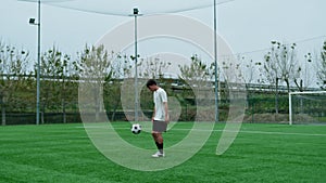 Player dribbles tricks with his feet lonely in the soccer field