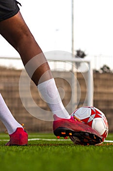 Player feet with the ball scoring a goal.