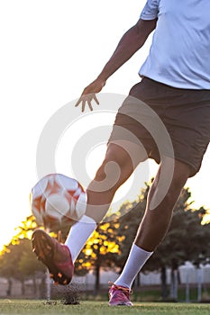 Player feet with the ball scoring a goal. Football player on the field running with the ball.