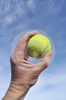 Player Gripping a Yellow Tennis Ball