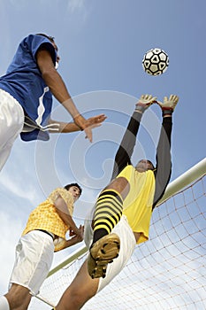 Player Heading Soccer Ball While Goalkeeper Trying To Save It