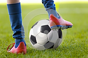 Player Kick a Soccer Ball on a Grass Pitch. The Perfect Football Kick. Young Footballer in Soccer Gear