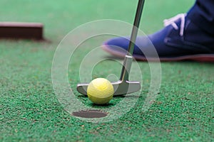 Player makes a decisive blow in the game of mini golf photo