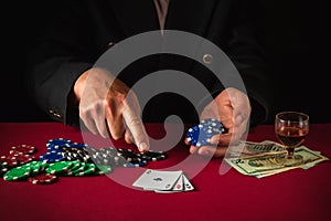 The player points with his finger at playing cards with a winning combination of three of a kind or set. Lucky win in the poker