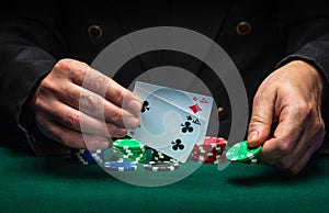 The player points to the winning combination of one pair in a poker game on a green table with chips and in a club