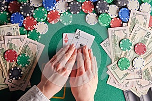 A player in a poker casino shows a pair of aces against the background of chips and money of dollars. Victory, success. Gaming