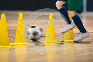 Player Practicing Indoor Soccer Dribbling Skills Running Between Yellow Training Cones photo