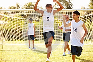 Player Scoring Goal In High School Soccer Match