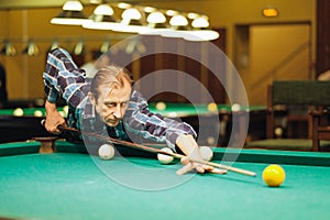 The player takes aim at the ball in Billiards