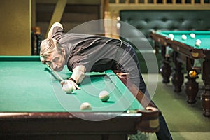 The player takes aim at the ball in Billiards