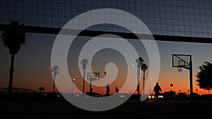 Players on basketball court playing basket ball game, sunset beach, California. photo