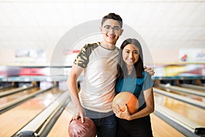 Players With Bowling Balls In Alley At Club