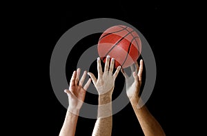 Players hand reaching for basketball in a competition