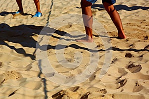 players shadow on the sand, spiking motion clearly outlined