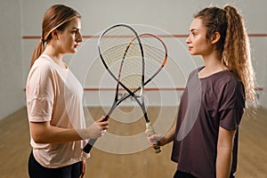 Players with squash rackets stands face to face