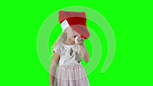 Playful 5 years old girl child playing with Christmas Santa hat. chroma key