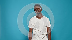 Playful adult juggling lemons and standing over blue background