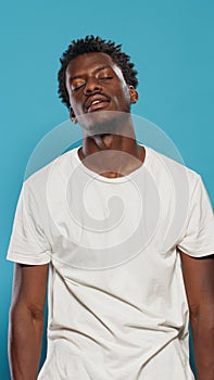 Playful adult juggling lemons and standing over blue background