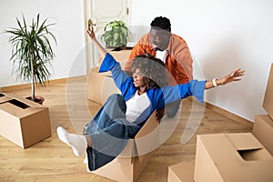 Playful african american couple having fun in their home on moving day