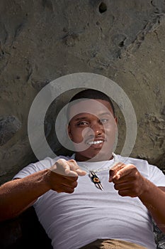 Playful African American guy gesturing laying down