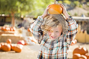 Playful Boy Holding His Pumpkin at a Pumpkin Patch
