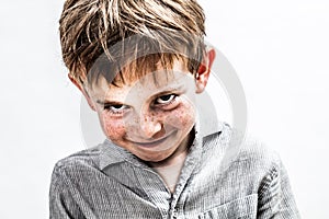 Playful boy smiling, looking mischievous for shy child humour