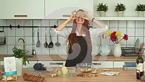 Playful Caucasian Girl Having Fun at Cozy Kitchen. Funny Red head girl.
