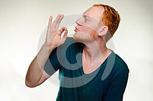 Playful, cheerful, red haired man show gesture perfecto. caucasian male gourmet like tasty delicious. great job photo