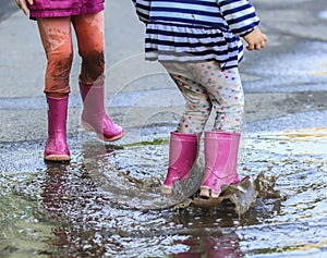 Playful child outdoor jump into puddle