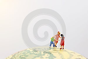 Playful children holding hands on the globe
