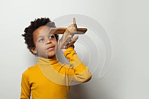 Playful clever black child boy with plane model