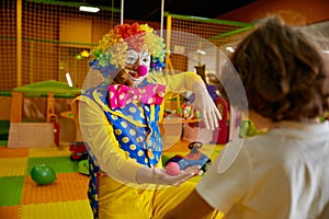 Playful clown showing tricks with nose carnival decoration at birthday party