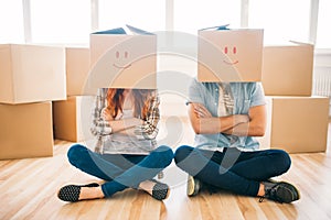 Playful couple with boxes on heads, housewarming