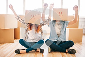 Playful couple with boxes on heads, housewarming