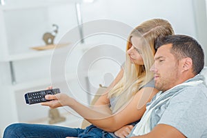 Playful couple fighting over TV remote