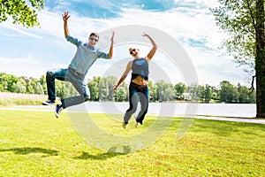 Playful couple jumping in the park
