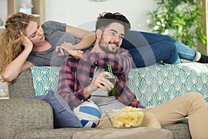 playful couple in love sitting on couch