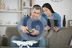 playful couple playing video games on sofa