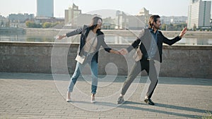 Playful couple young people dancing outdoors laughing having fun together