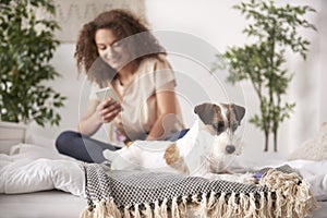 Playful dog and teenage girl in bedroom