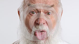 Playful Elderly Man Sticking Out Tongue in Fun Expression Close-Up