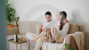 Playful family flirting couch closeup. Handsome man cuddling woman relaxing sofa