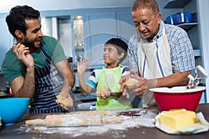Playful family holding dough while preparing food