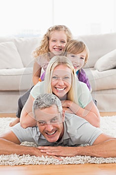 Playful family lying on each other in living room