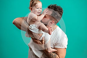 Playful father carrying his smiling infant child on neck over blue background