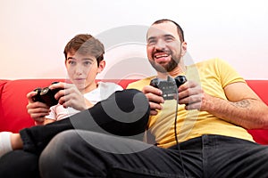 Playful father and son playing video game