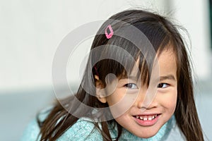 Playful friendly little girl leaning forwards photo