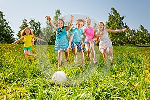 Playful friends running to the ball in field