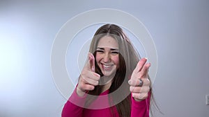 Playful girl pointing camera with finger gun gesture woman beautiful positive cute model girl posing indoor looking at